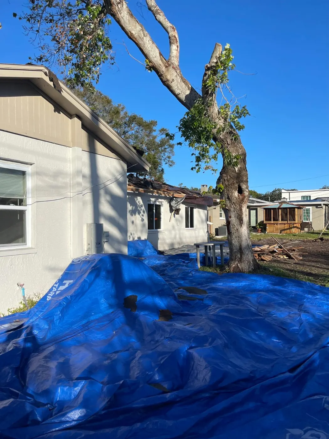 Emergency tarp installed after a tree damaged a home in a hurricane