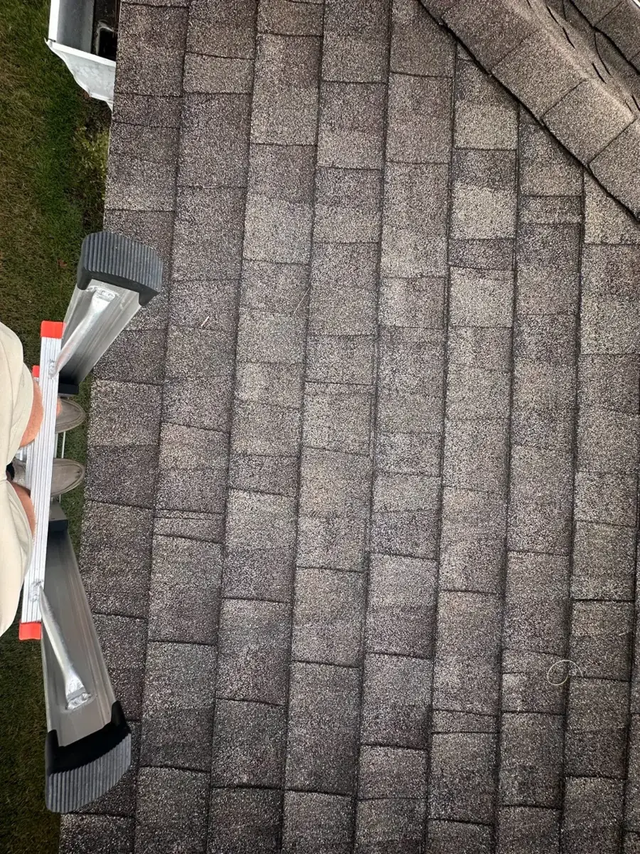 Shingles lifted along a rake edge during a storm damage inspection