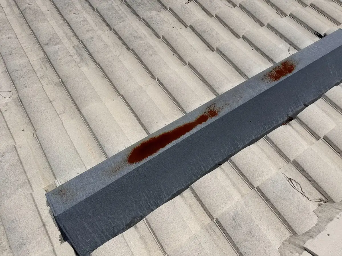 Concrete tile roof with a displaced, temporarily secured ridge after a hurricane
